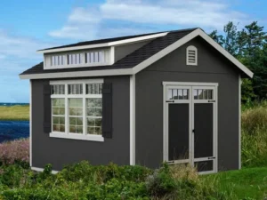 Windemere 10x12 Wooden Storage Shed with double doors, windows, and a dormer in a backyard setting."
